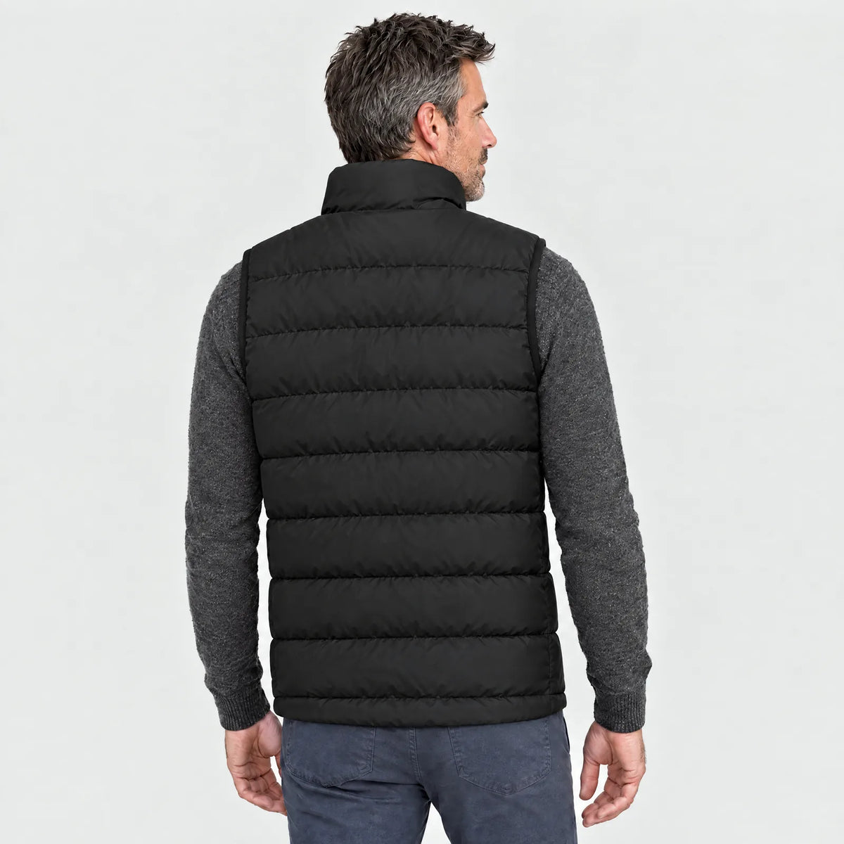 Man wearing the black heated vest, back view
